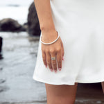 This sophisticated sterling silver bangle from our Cyclical collection is the perfect way to add a timeless flair to any look. Its classic design features a timeless silhouette that pairs effortlessly with a variety of styles. Wear with the cyclical thick or thin ring to complete the look.