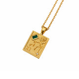 A gold pendant necklace featuring engraved  zodiac symbols and stars, accented by a green rectangular stone and a lab grown diamond, suspended from a gold chain on a white background.