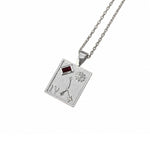 A silver-toned square pendant necklace featuring an astrological symbol, Roman numeral IV, a flower motif, and a small red rectangular gemstone, suspended from a matching chain on a white background.