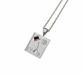 A silver-toned square pendant necklace featuring an astrological symbol, Roman numeral IV, a flower motif, and a small red rectangular gemstone, suspended from a matching chain on a white background.