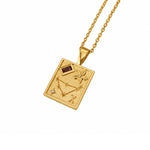A gold pendant necklace featuring a square zodiac design with engraved stars, constellations, a flower motif, and a small dark red rectangular gemstone, shown on a white background.