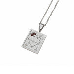 A silver pendant necklace featuring a rectangular pendant engraved with a constellation design, a flower motif, and a small dark red rectangular gemstone, shown on a white background.