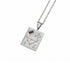 A silver pendant necklace featuring a rectangular pendant engraved with a constellation design, a flower motif, and a small dark red rectangular gemstone, shown on a white background.