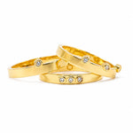 Three gold vermeil rings with lab grown diamonds set within a bezel, on a white background.