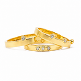 A stack of three gold vermeil rings with lab grown diamonds set in a solid sterling silver base, arranged on a plain background.