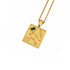A gold pendant necklace featuring a square celestial map design with Roman numerals, a constellation, a wheat stalk, and a small green rectangular stone, shown on a white background.