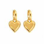 A pair of gold hoop earrings with polished heart-shaped dangles, shown on a solid white background.