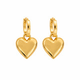 A pair of gold hoop earrings with polished heart-shaped dangles, shown on a solid white background.