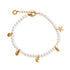 A delicate pearl bracelet with gold-toned metal charms, including a starfish, seashell, leaf, and a lobster clasp, displayed on a clean white background.
