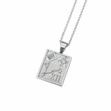 A silver rectangular pendant necklace featuring an astrological design with a small light blue gemstone and Roman numeral XII, suspended from a silver chain on a white background.