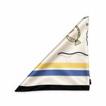 A folded white satin neck scarf with a black line art face design, green wreath detail, and horizontal stripes in yellow, blue, and black.