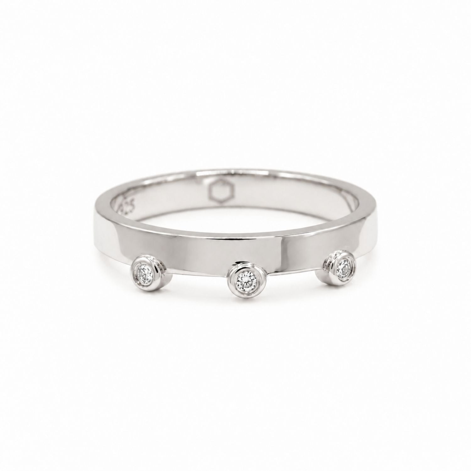 One slim silver ring, featuring three lab-grown diamonds, against a white background.