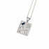 A silver-toned rectangular pendant necklace featuring an engraved constellation design, a small textured circular detail, and a dark blue rectangular inset near the top left, suspended from a matching chain on a white background.