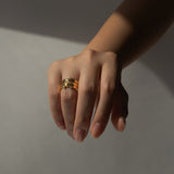 Three gold vermeil rings with lab grown diamonds set within a bezel, on a ring finger of hand with a light grey background.