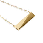 A gold vermeil necklace with a geometric slanted rectangular pendant on a chain.