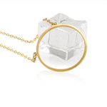 A 14K gold plated circular necklace con a piece of ice on white background shot in studio.