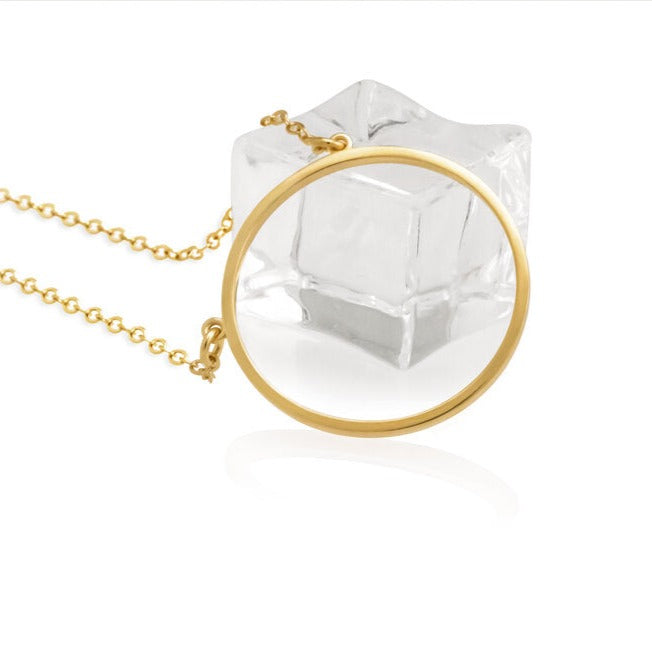 A 14K gold plated circular necklace con a piece of ice on white background shot in studio.