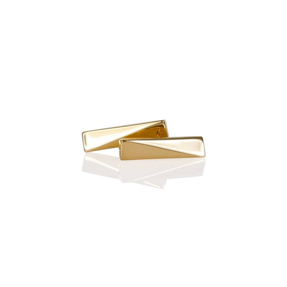 A pair of gold vermeil stud earrings on a white background with a reflection below them.